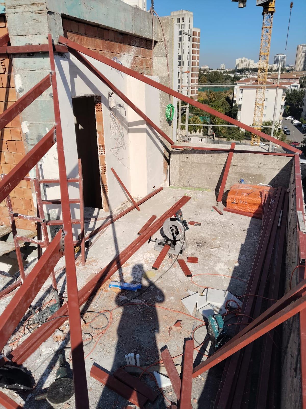 Teras kenarı boyunca yerleştirilen çelik dikmeler ve tuğla duvar birleşimi
