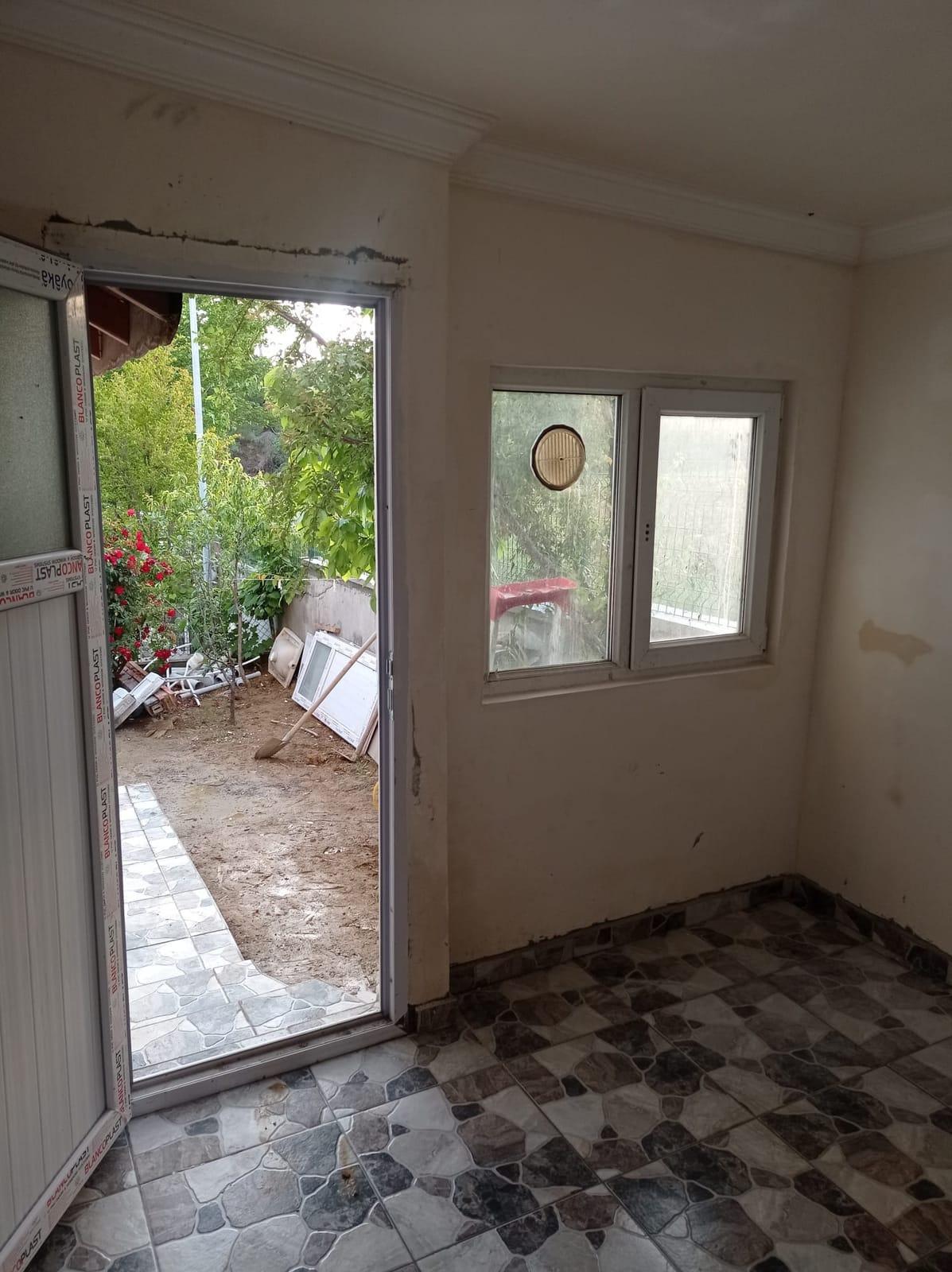 PVC kapı ve pencere takılmış, zemini kaplanmış oda